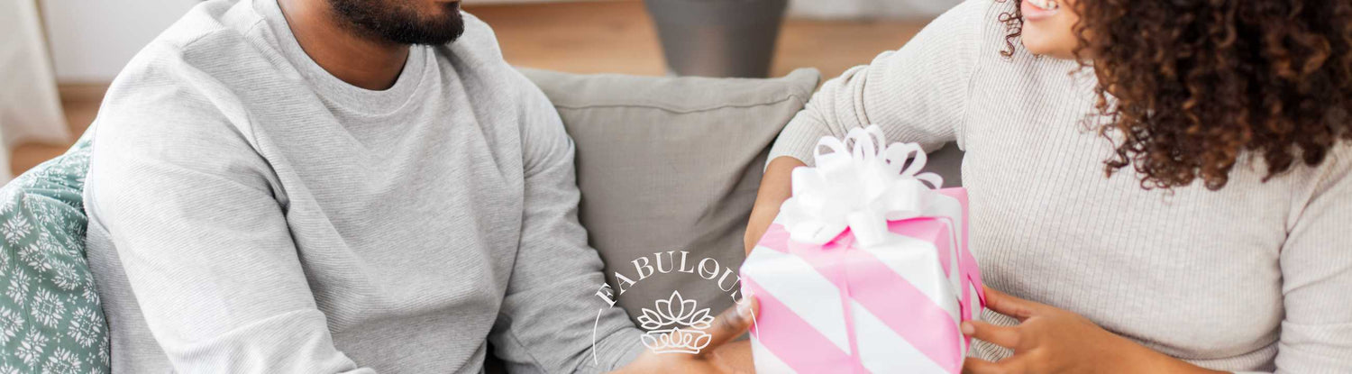 Couple exchanging a beautifully wrapped gift, with smiles and joy, courtesy of Fabulous Flowers and Gifts.