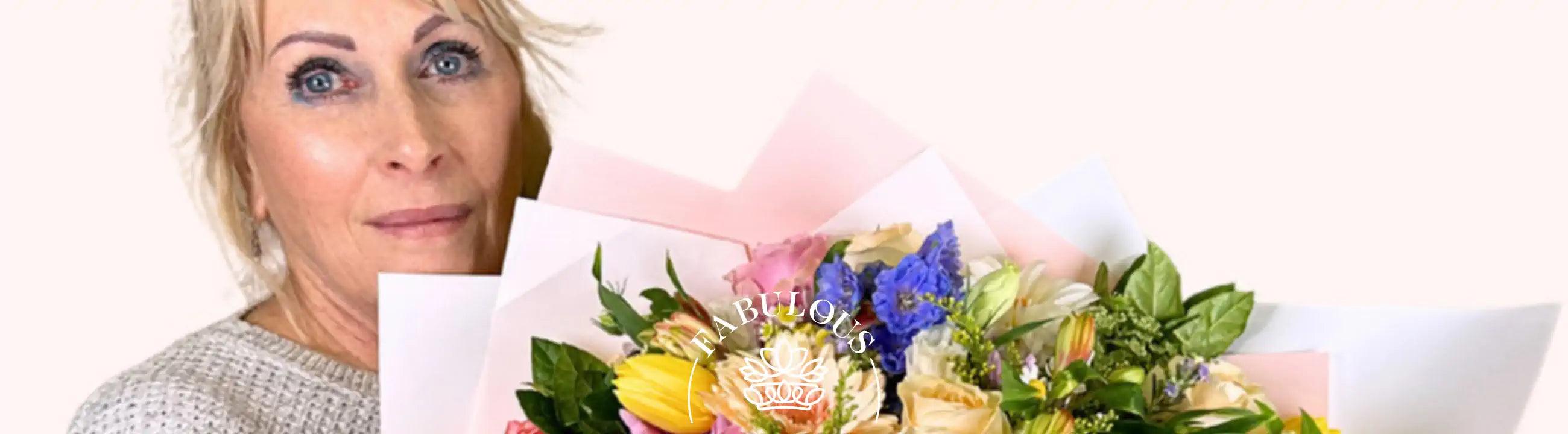 Close-up of a vibrant and colorful bouquet featuring a mix of yellow, pink, blue, and white flowers, beautifully arranged. Fabulous Flowers and Gifts.