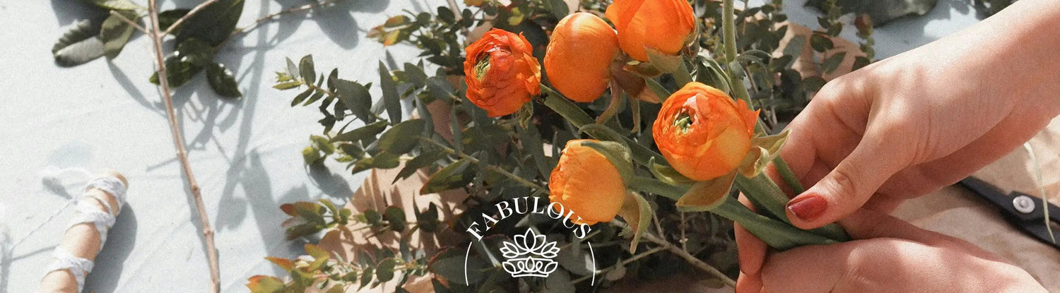 Close-up of a florists hands holding orange flowers 