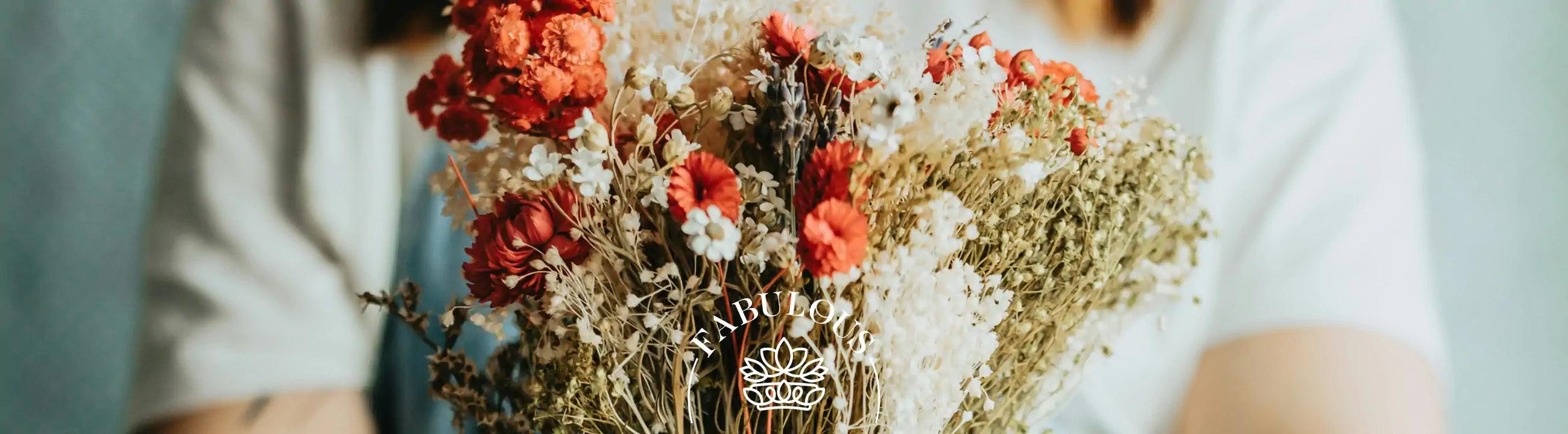 A person holding a beautifully arranged bouquet of red and white flowers. Fabulous Flowers and Gifts.