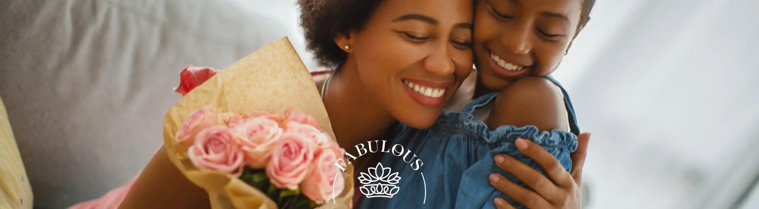 A mother and daughter sharing a warm embrace, with the mother holding a bouquet of pink roses. Fabulous Flowers and Gifts.