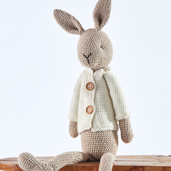 "Elegant hand-knitted Benedict Bunny Gentleman wearing a soft cream cardigan, perfect for a charming nursery decor.