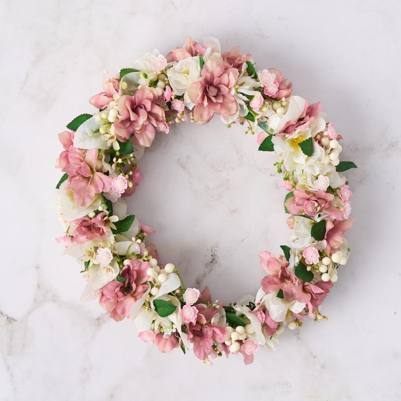 Pink and white floral crown with blush blooms and delicate greenery.