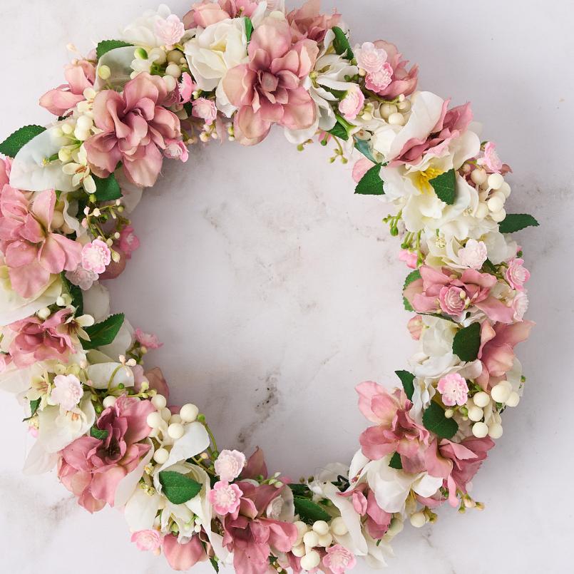 Close-up of blush and white flower crown featuring soft petals and green accents.