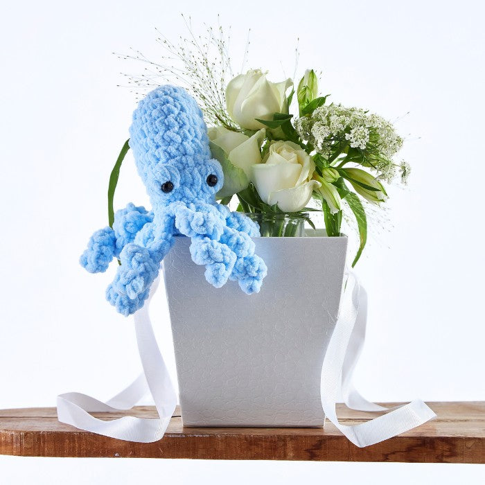 Handmade blue octopus plush toy with fresh white roses in the Blue Reef Blossom Bag, ideal for newborn gifts.