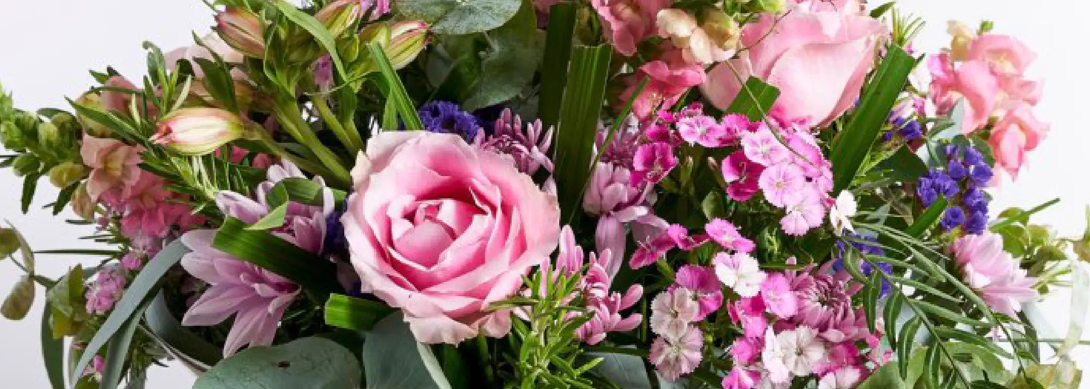 Close-up of a beautiful floral arrangement featuring pink roses, purple and pink flowers with lush green leaves. The text reads 'The Perfect Corporate Gift for Every Occasion.' Corporate Gifting. Fabulous Flowers and Gifts.