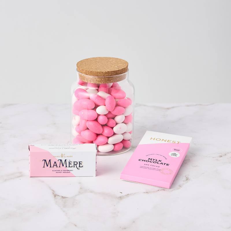 Candy Kisses Hamper with a jar of pink and white sweets, almond & cranberry nougat, and a pink mylk chocolate bar.