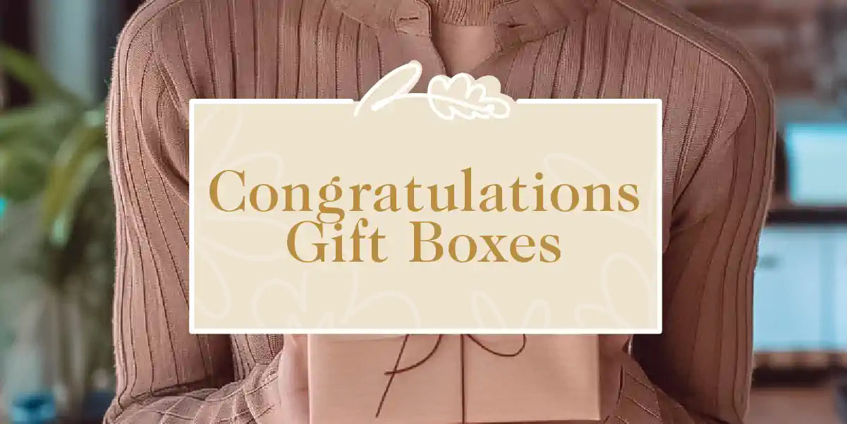 A person holding an elegantly wrapped gift box to celebrate a special occasion. Fabulous Flowers and Gifts - Congratulations Gift Boxes