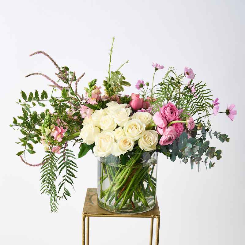 Creative Poetry Flower Arrangement featuring white roses and pink blooms in a glass vase.