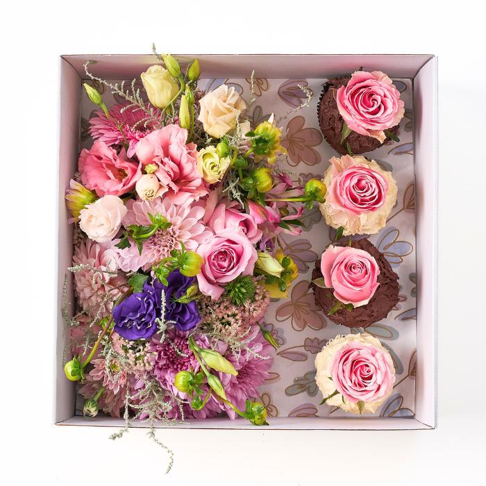 Cupcake Bloom Box from Fabulous Flowers & Gifts, featuring a blend of pink and purple flowers like roses and dahlias, with rose-topped chocolate cupcakes.