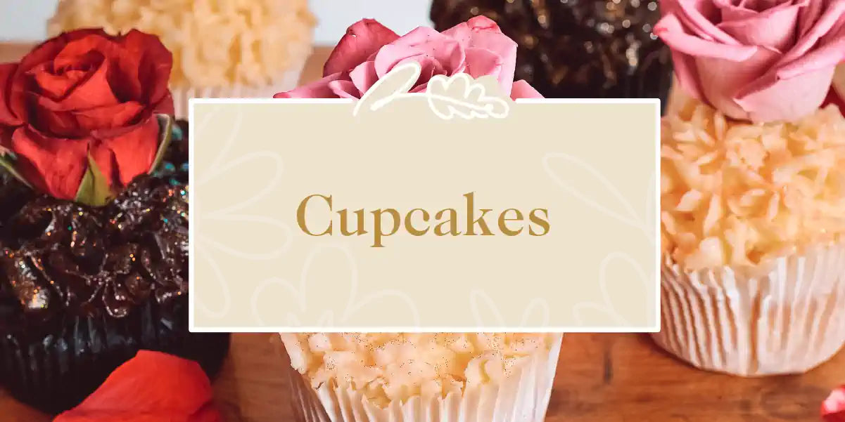 Cupcakes Collection: Close-up of elegant cupcakes adorned with decorative icing and fresh roses, ready to delight any occasion. Fabulous Flowers and Gifts.