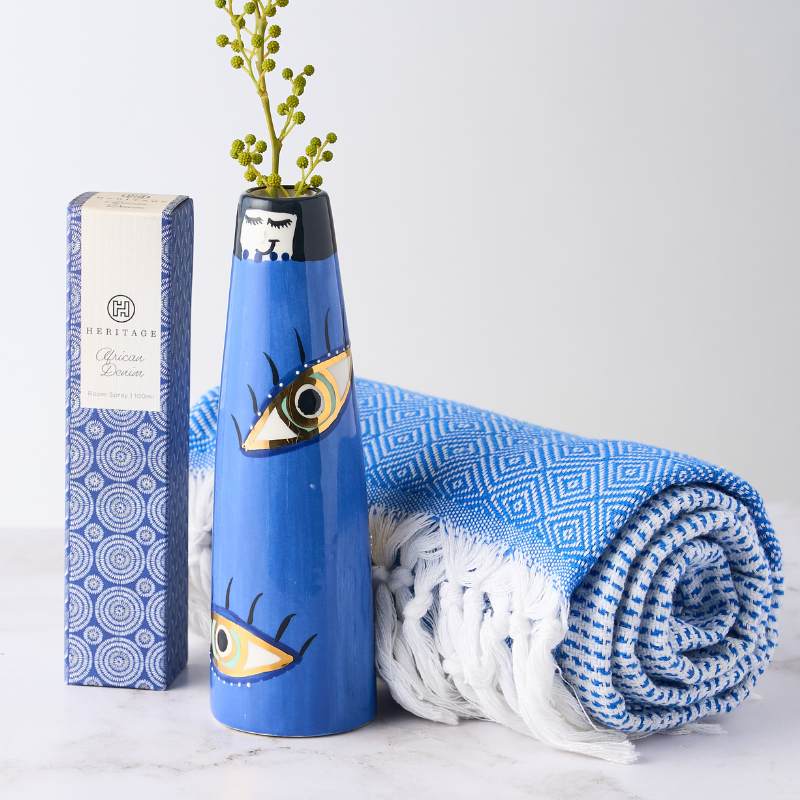 Eyeland Holiday Gift featuring a unique eye-patterned vase, blue Turkish towel, and scented room spray. Perfect for a sophisticated touch.