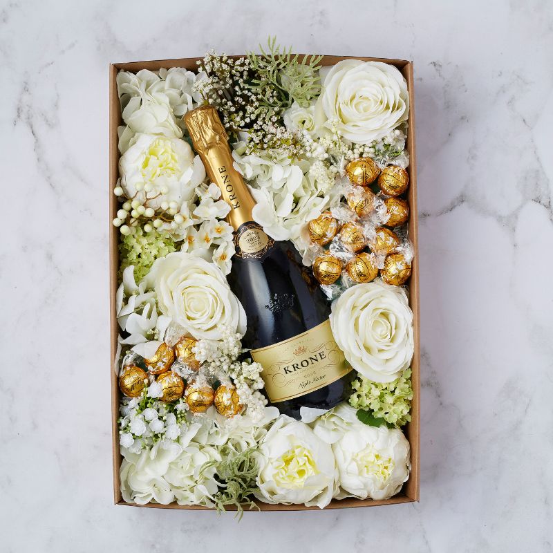 Elegant gift box with Krone Night Nectar Brut, Ferrero Rocher chocolates, and white silk roses.