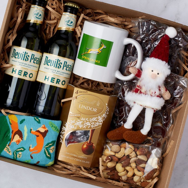 Festive Cheer Hamper featuring Devil’s Peak Hero beer, Springboks mug, Santa plush, Lindt chocolates, mixed nuts, and festive socks