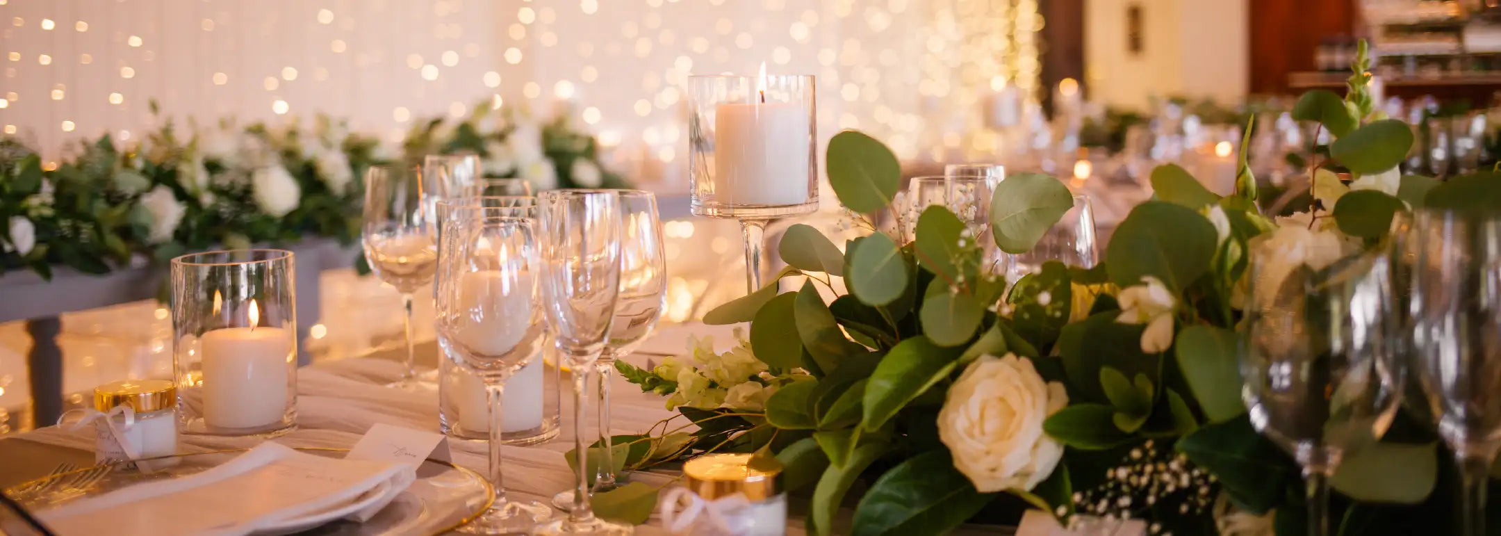 Exquisite event table setting with floral centrepieces, candles, and elegant glassware, creating a luxurious and sophisticated ambiance for special occasions. Fabulous Flowers and Gifts.