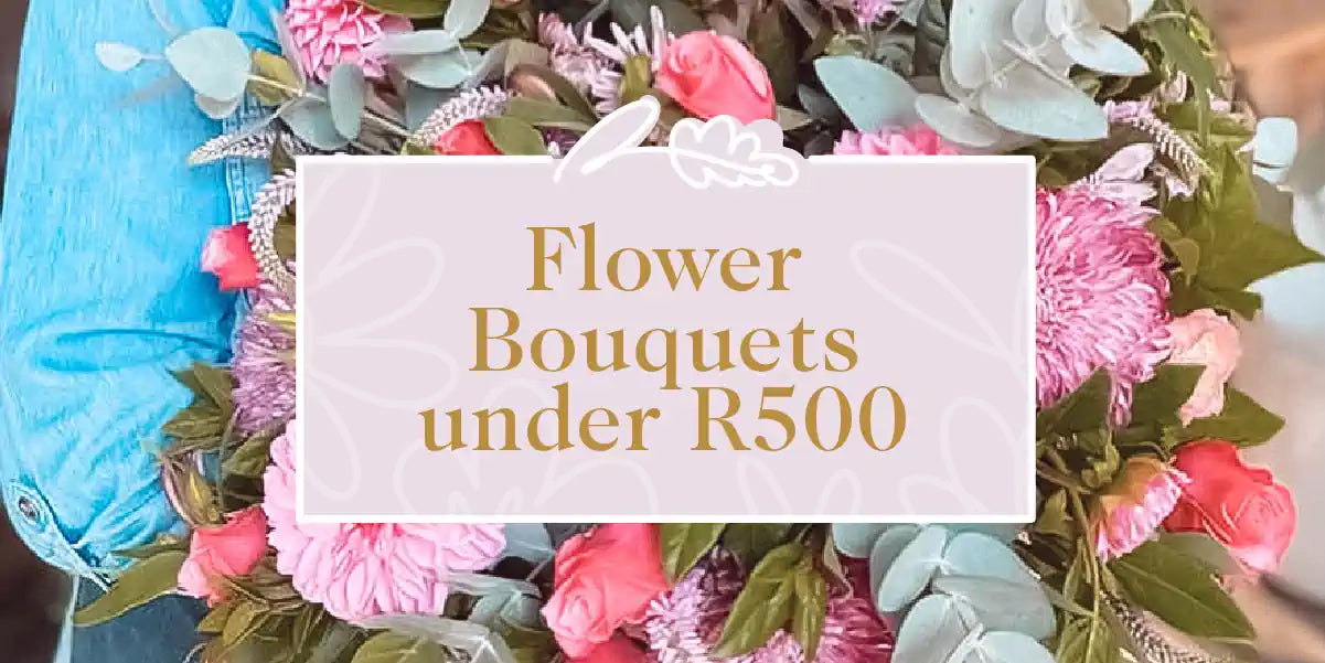 A person in a denim jacket holding a beautiful bouquet of mixed flowers including roses and eucalyptus. Fabulous Flowers and Gifts - Flower Bouquets Under R500