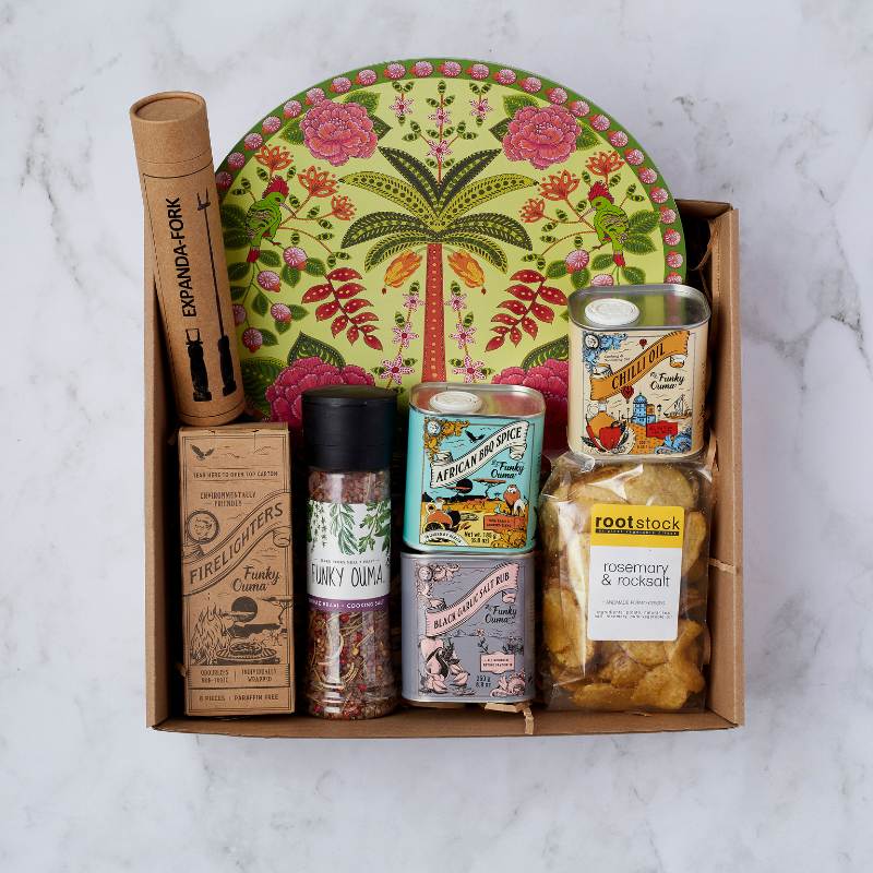 Get Cookin’ Goodlookin’ gift box with Funky Ouma spices, firelighters, chilli oil, and a colourful tray from Fabulous Flowers & Gifts.