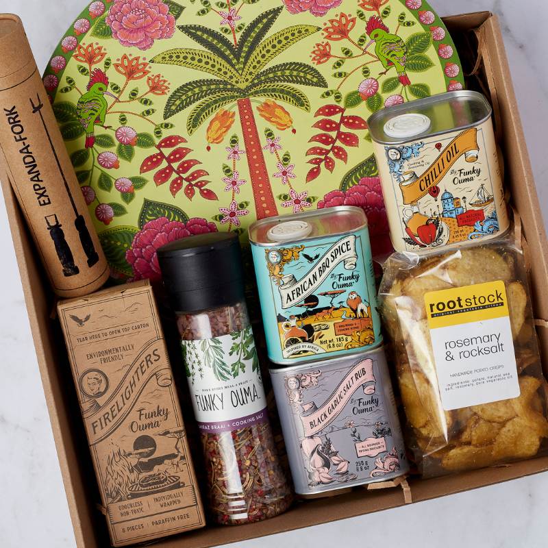 Close-up of Get Cookin’ Goodlookin’ gift box featuring Funky Ouma spices, firelighters, chilli oil, and more from Fabulous Flowers & Gifts.