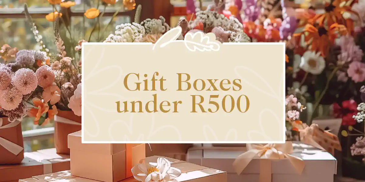 A variety of gift boxes under R500 creatively arranged with stunning floral decorations around. Fabulous Flowers and Gifts - Gift Boxes under R500