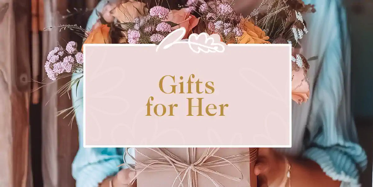 A woman holding a gift box decorated with a lovely floral arrangement, perfect for any special woman in your life. Fabulous Flowers and Gifts - Gifts for Her