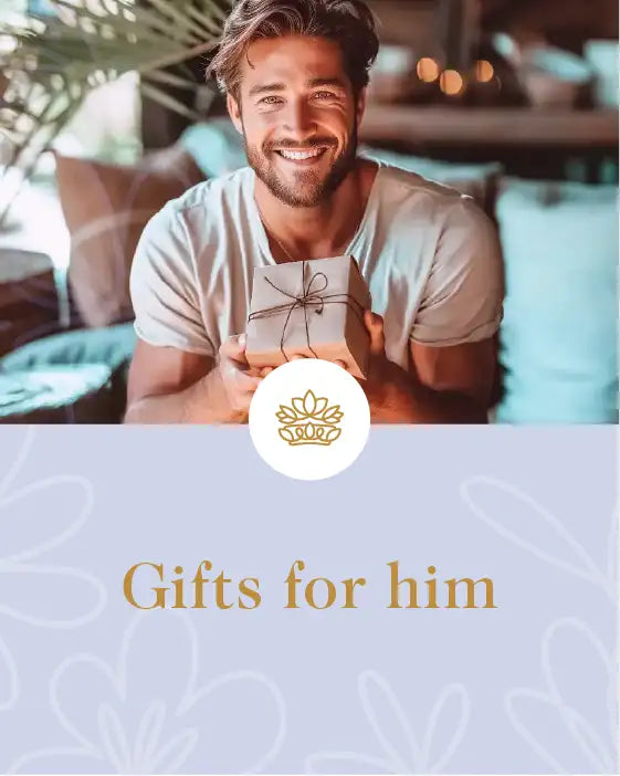 Smiling man holding a gift box tied with string, sitting in a cosy setting. Fabulous Flowers and Gifts. Gifts for Him Collection.