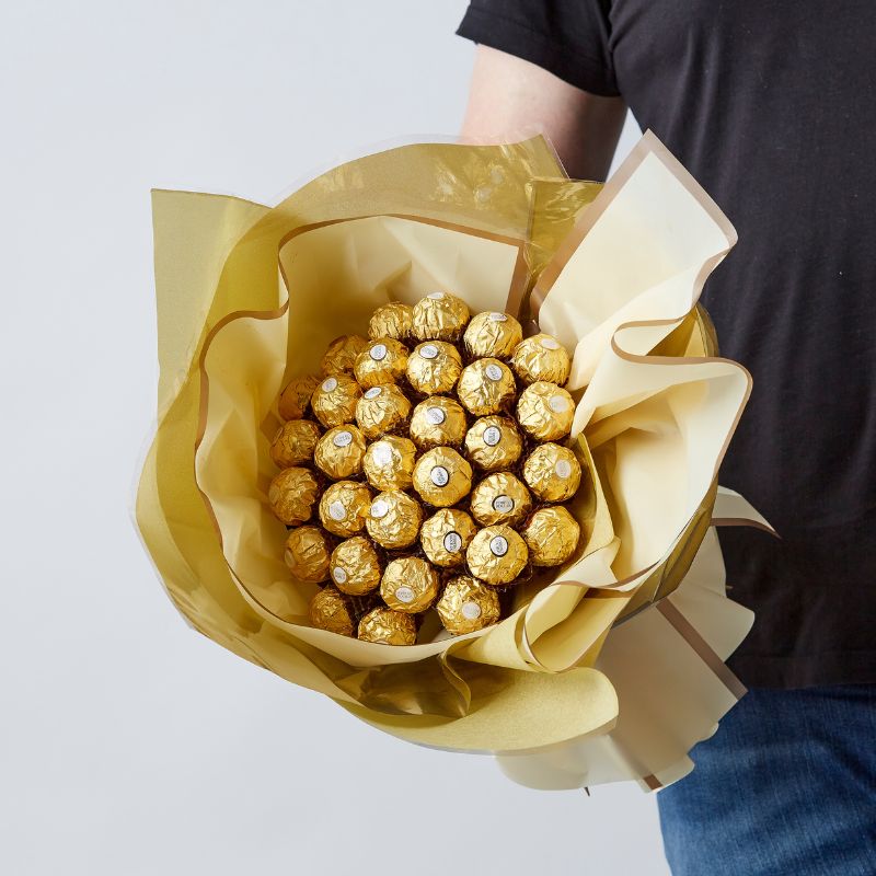 Close-up of a golden Ferrero Rocher bouquet with elegant wrapping, ideal for luxury chocolate lovers.