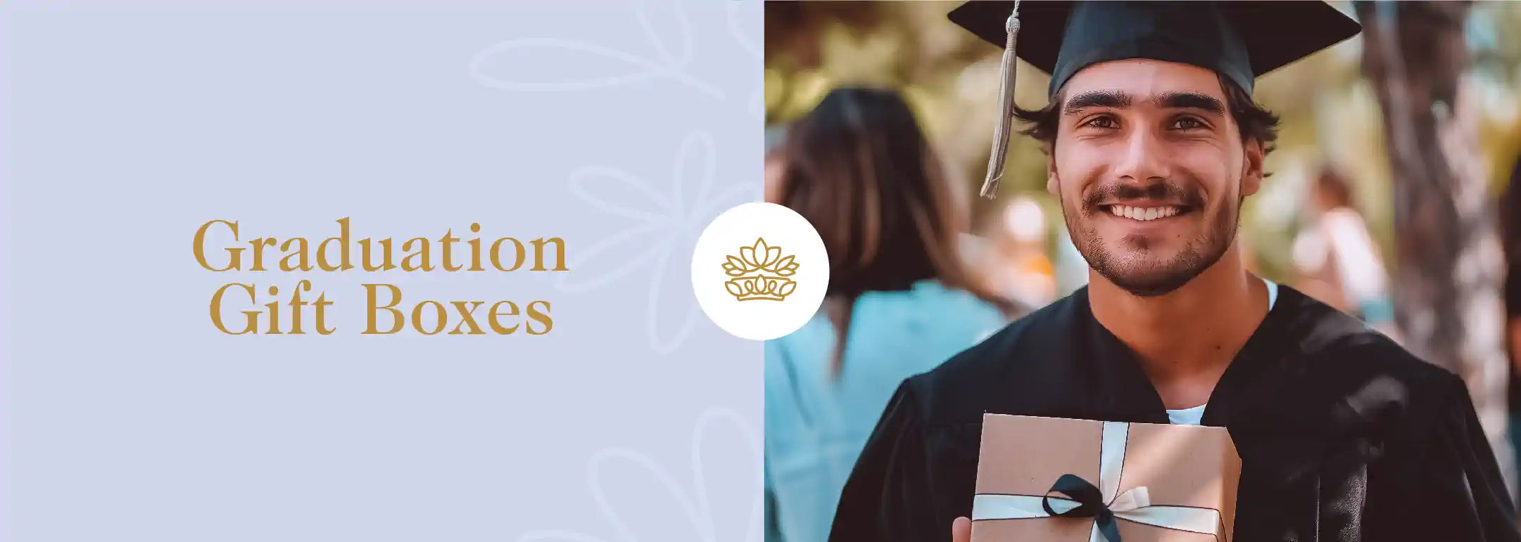 A young man in a graduation cap and gown, holding a gift box with a ribbon. Fabulous Flowers and Gifts - Graduation Gift Boxes