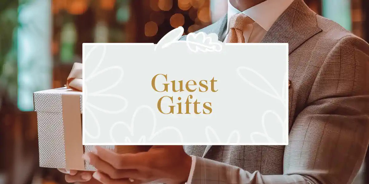 A man in a smart suit holding an elegantly wrapped guest gift with a sophisticated background. Fabulous Flowers and Gifts - Guest Gifts