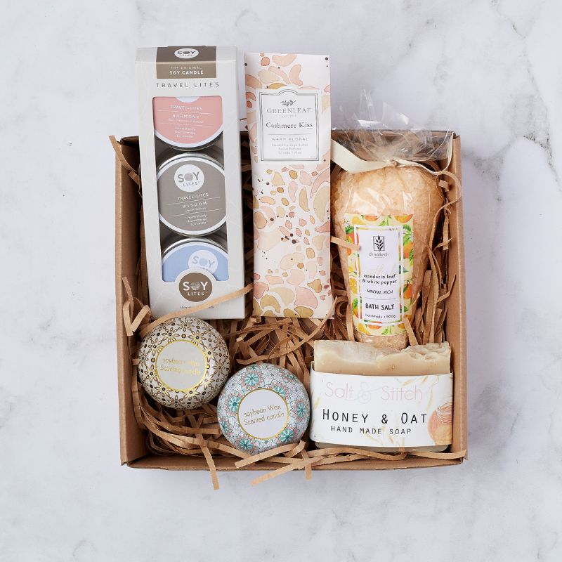 Luxurious gift set featuring soy candles, Cashmere Kiss sachet, bath salt, and handcrafted honey oat soap for relaxation and self-care.