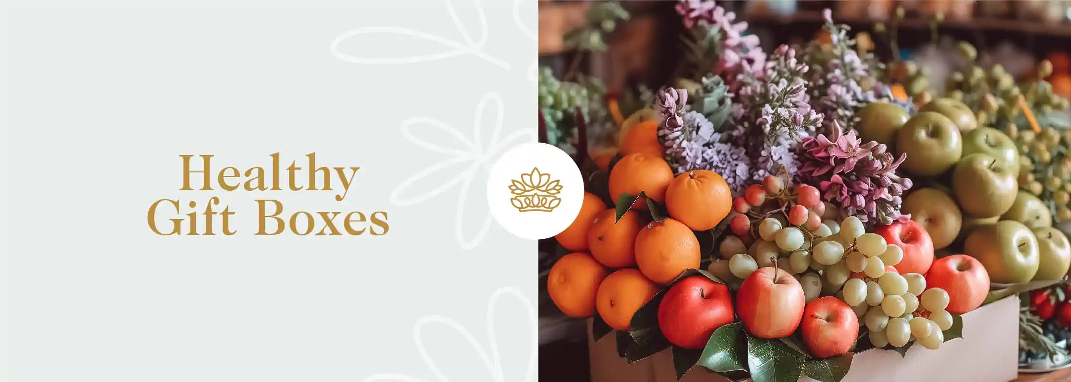 A vibrant assortment of fresh fruits including oranges, apples, and grapes, complemented by delicate purple flowers, curated into a healthy gift box. Part of the Healthy Gift Boxes Collection from Fabulous Flowers and Gifts.