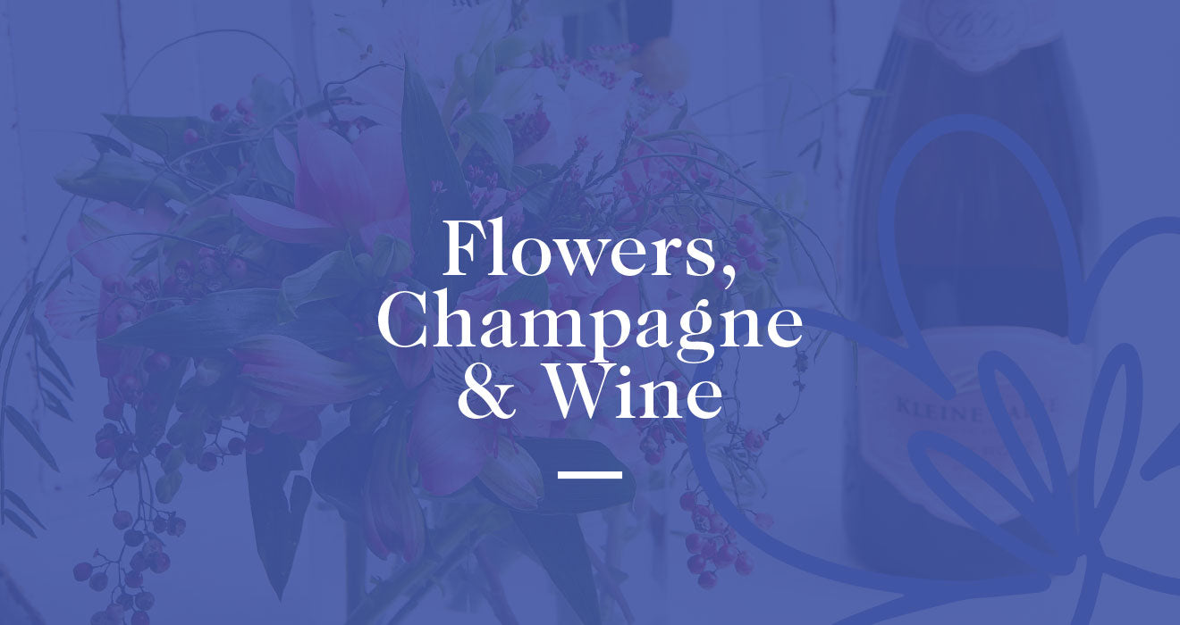 Flowers with a bottle of champagne and wine in the background, displayed with elegant text overlay. Fabulous Flowers and Gifts. Flowers, champagne and wine.