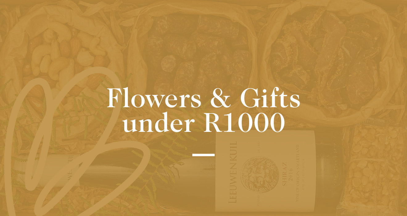 Assorted flowers and gifts including a bottle of wine and dried fruits with text overlay. Fabulous Flowers and Gifts. Flowers and Gifts under R1000.