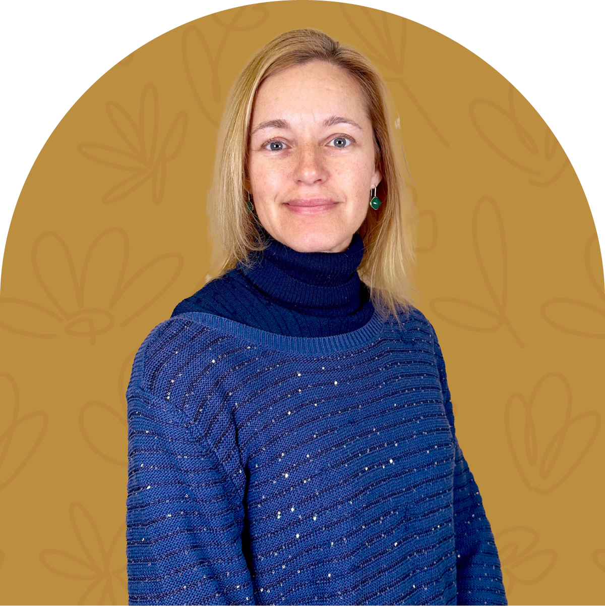 Portrait of Jayne, a green-loving team member at Fabulous Flowers for 2.5 years, wearing a blue sweater and standing against a golden background. MEET THE TEAM at Fabulous Flowers and Gifts.
