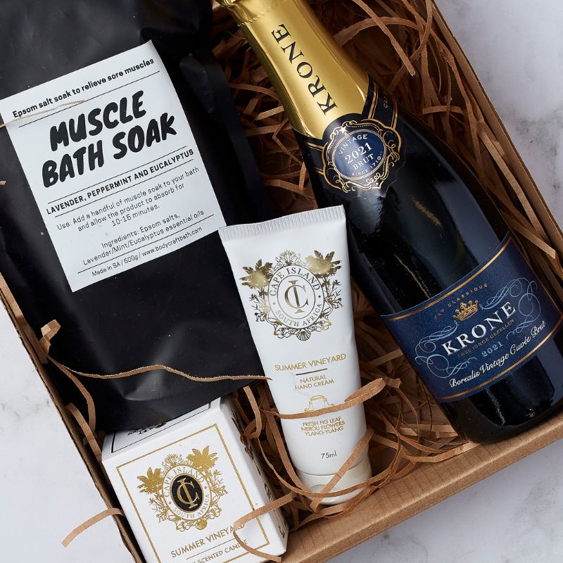 Luxury gift set featuring Krone champagne, muscle bath soak, and skincare products