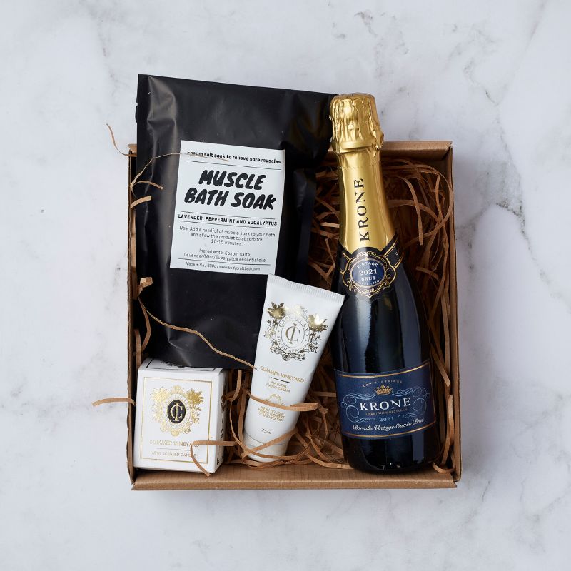 Gift box with Krone champagne, muscle bath soak, scented candle, and hand cream