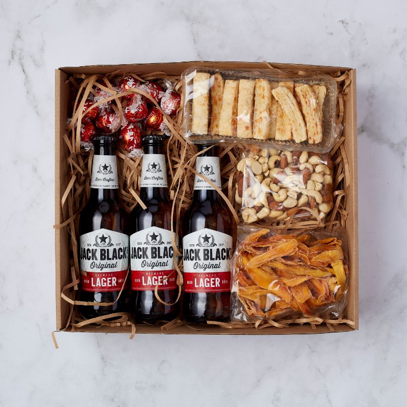 Luxurious beer and snack hamper featuring Jack Black Lager, assorted nuts, dried mango, cheese sticks, and Lindt chocolate truffles.