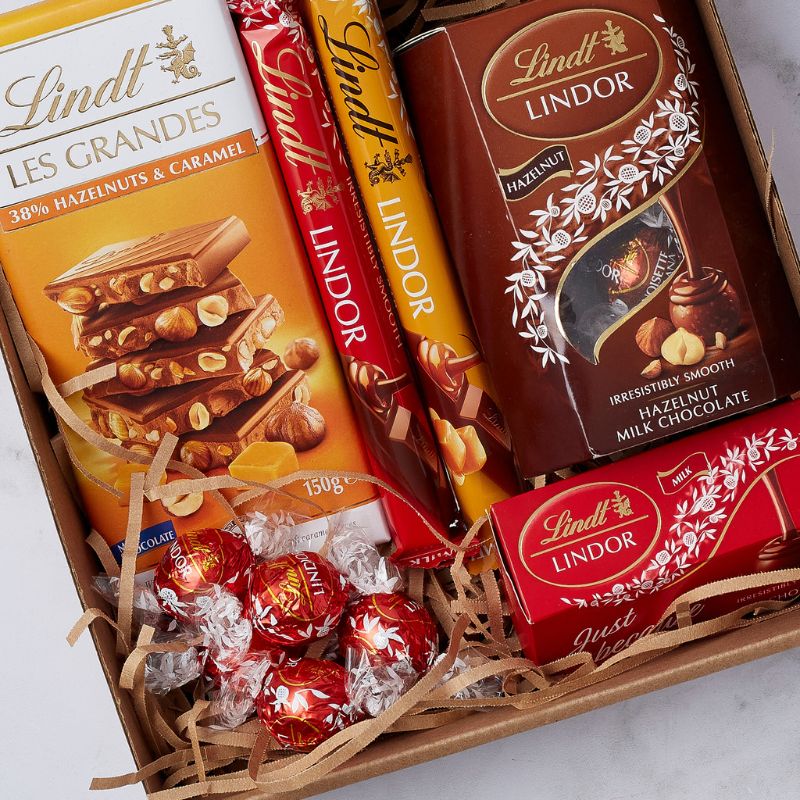 Close-up of Lindt chocolate assortment including Les Grandes, Lindor bars, and hazelnut milk chocolate