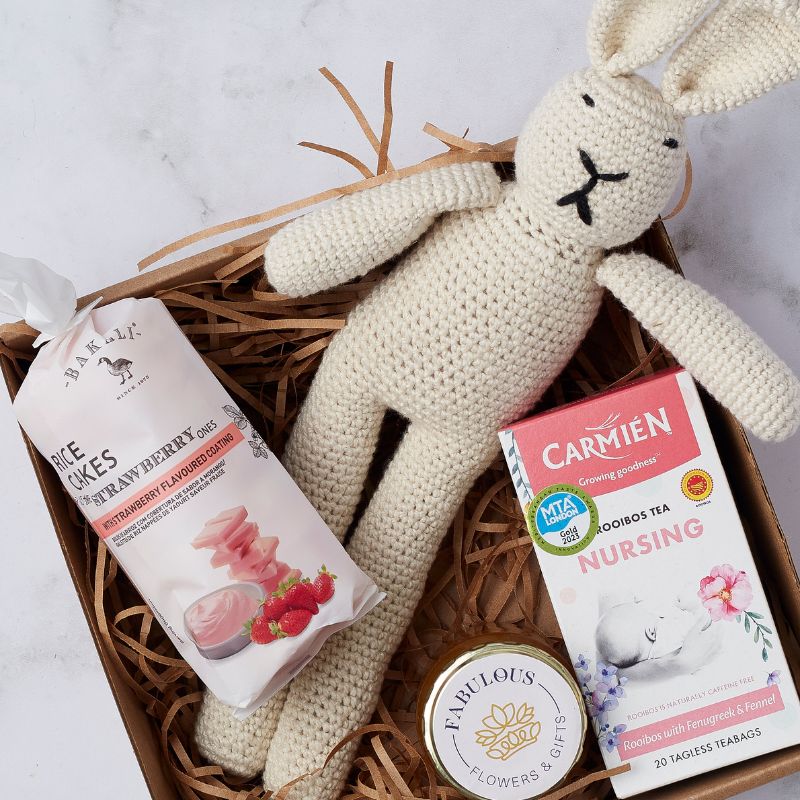 Gift box featuring a soft crocheted bunny toy, strawberry-flavoured rice cakes, Carmién nursing rooibos tea, and Fabulous Flowers candle.