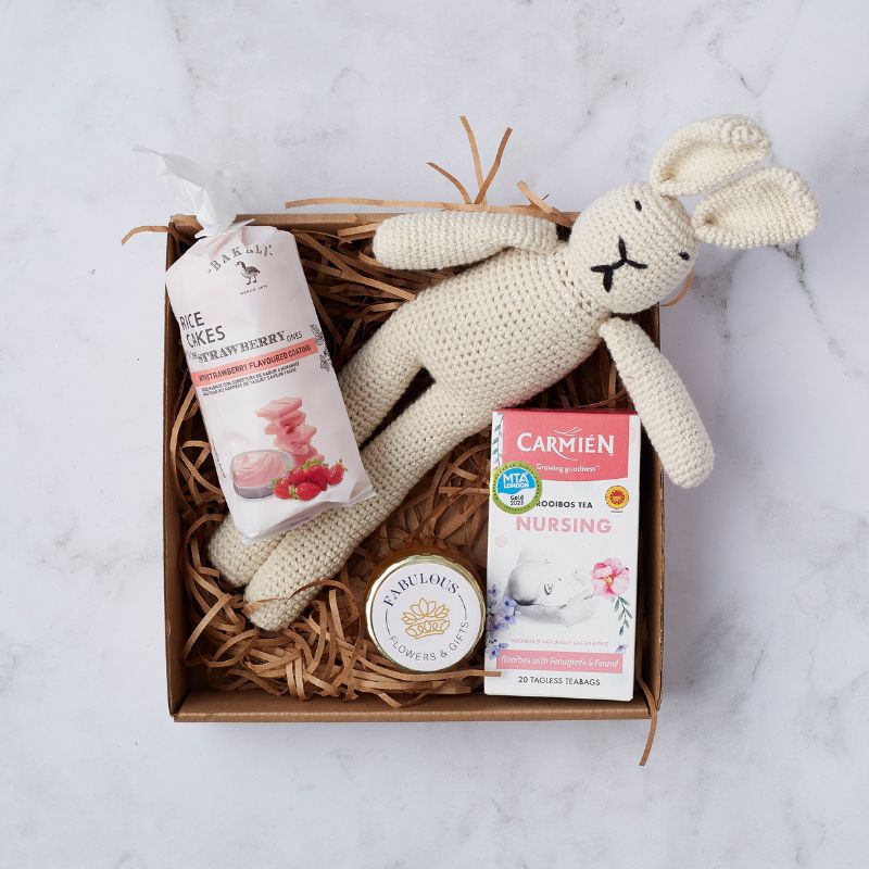 Gift set for new parents with a crocheted bunny, strawberry rice cakes, rooibos tea for nursing, and candle from Fabulous Flowers.