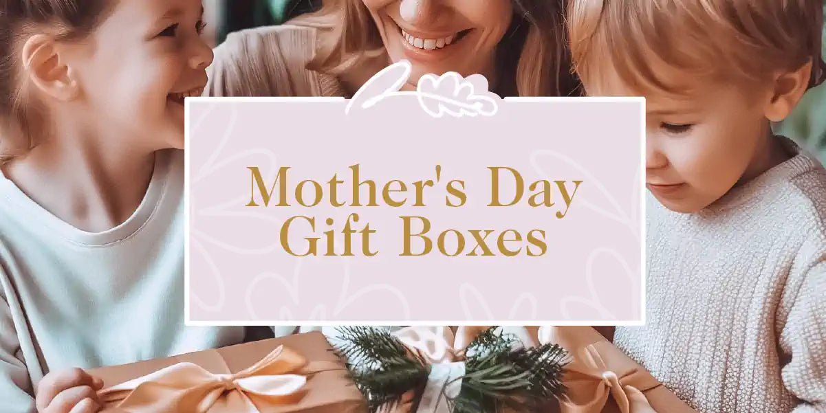 A delighted mother opening elegantly wrapped gift boxes with her children for Mother's Day. Fabulous Flowers and Gifts - Mother's Day Gift Boxes