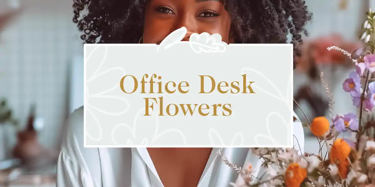 A smiling professional in an office with a lovely flower arrangement on her desk. Fabulous Flowers and Gifts - Office Desk Flowers