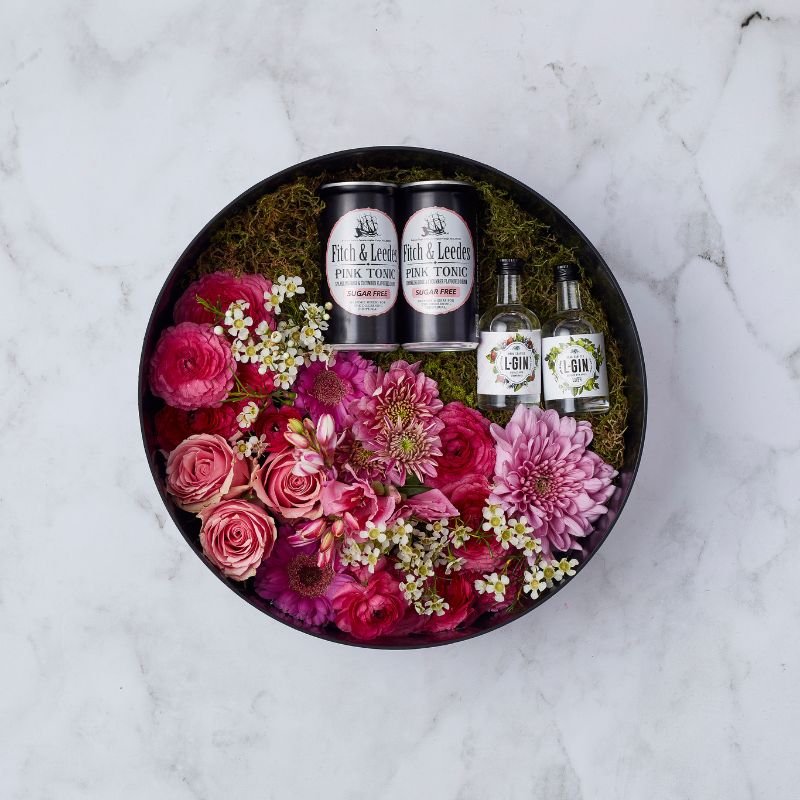 Pink floral arrangement with L-Gin miniatures and Fitch & Leedes Pink Tonic in a round black gift box