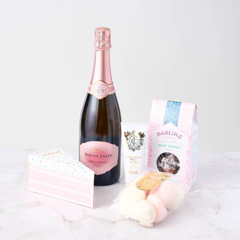 Rosé & Gourmet Delights Box featuring Kleine Zalze Brut Rosé, mint toffees, hand cream, coconut marshmallows, and a gift box.