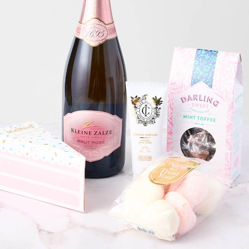 Rosé & Gourmet Delights Box with Brut Rosé wine, mint toffees, hand cream, coconut marshmallows, and a festive gift box. Perfect for celebrations.