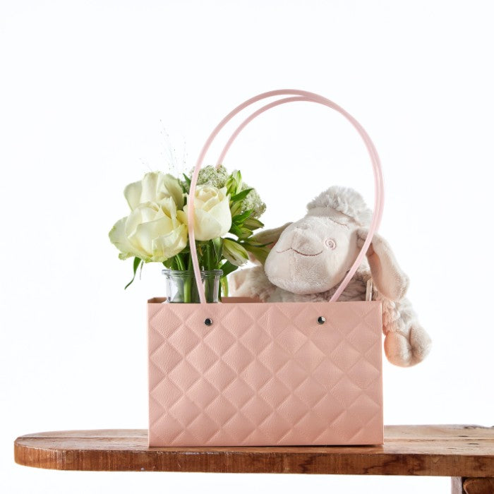 Rosy Lamb Gift Tote featuring a plush lamb nestled in a pastel pink quilted tote bag alongside fresh white roses and greenery, perfect for a luxury baby shower gift.