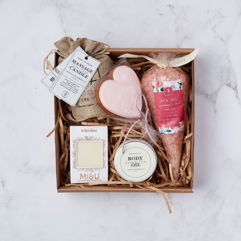 Gift box with massage candle, heart-shaped soap, gardenia and fern bath salts, artisan soap, and body oil.