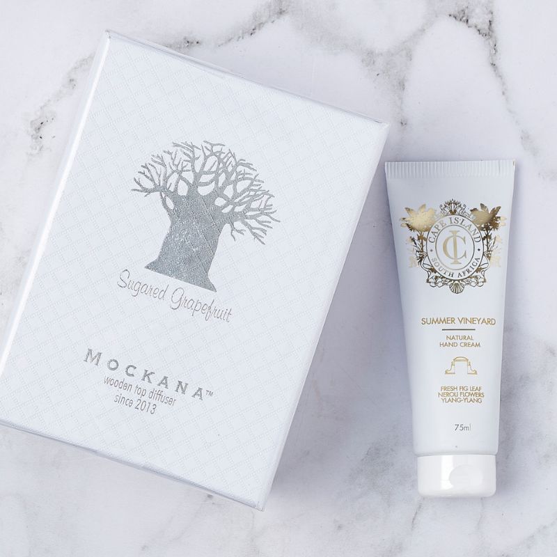 Close-up of Mockana sugared grapefruit diffuser box with Cape Island Summer Vineyard hand cream tube.