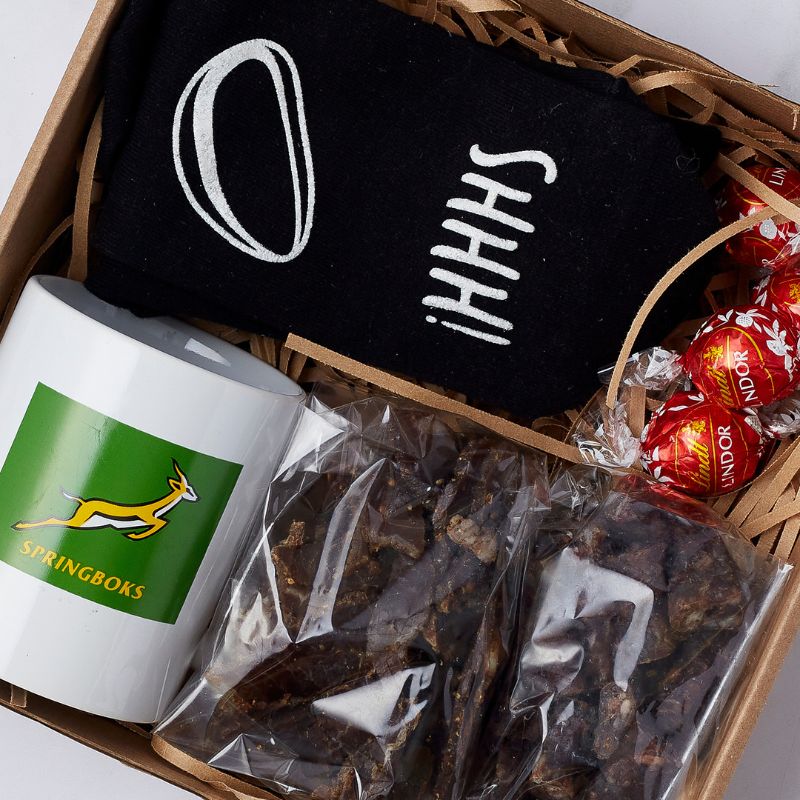 Close-up of Springbok Snack Surprise Gift Box featuring biltong, Springbok mug, socks, and Lindt chocolates.