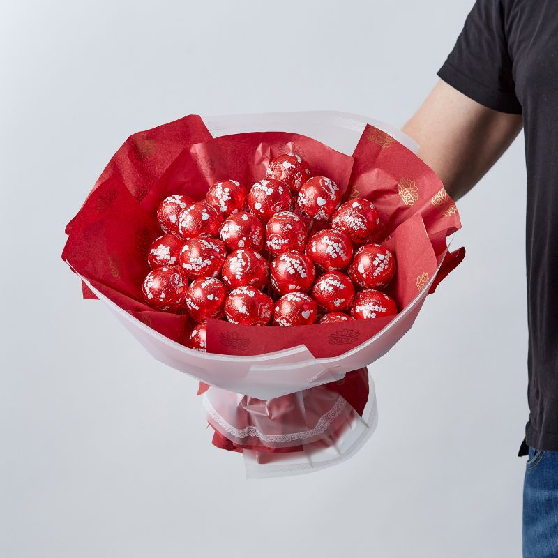  25 Sweetie Pie Delight Bouquet with red-wrapped Sweetie Pie chocolates arranged as a unique gift.