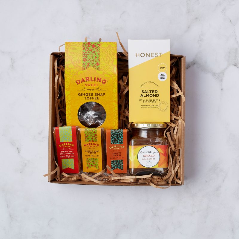 Gift box of artisanal treats featuring Darling Sweet ginger snap toffee, Honest salted almond chocolate, and blood orange jam